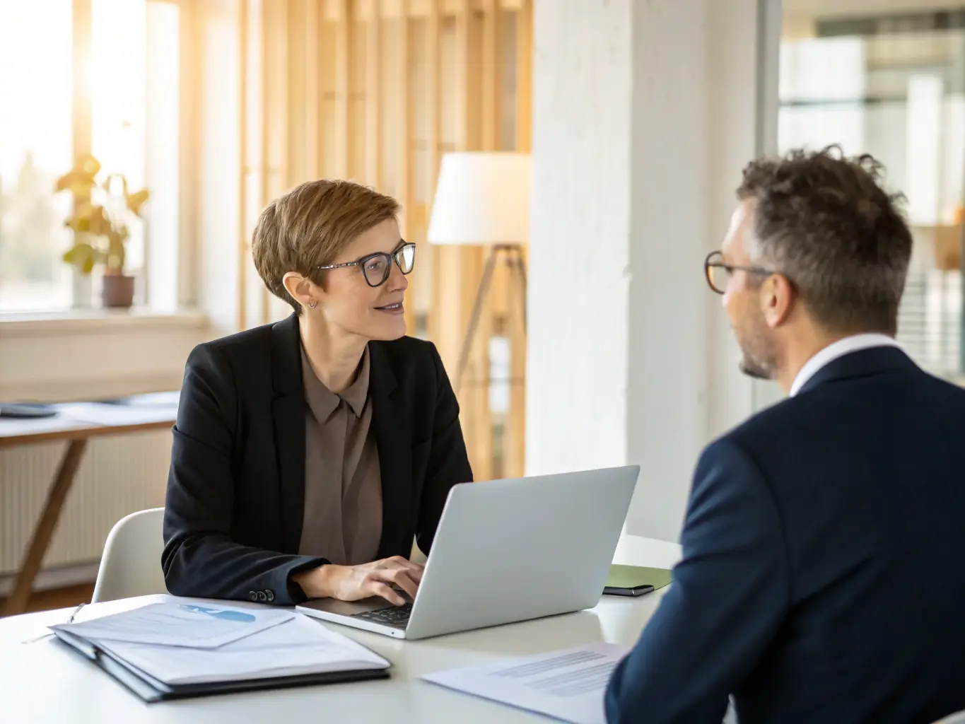 A professional agent from ABG Corp is discussing debt recovery strategies with a business owner in a modern office setting. The atmosphere is collaborative and solution-oriented.